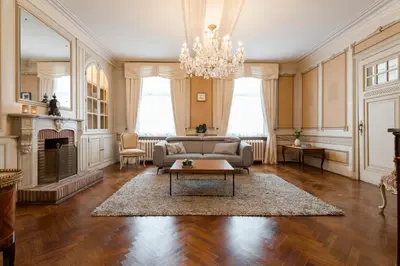 a living room with a couch and a chandelier at B&B Tannerie in Balen
