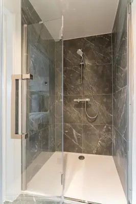 a shower with a glass door in a bathroom at B&B Tannerie in Balen