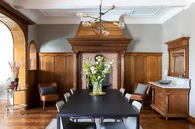a dining room with a table with a vase of flowers at B&B Tannerie in Balen