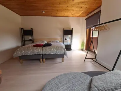 a bedroom with two beds and a wooden ceiling at Tussenbeke in Lede