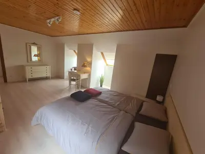 a bedroom with a large bed and a desk at Tussenbeke in Lede