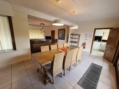 a dining room and living room with a table and chairs at Tussenbeke in Lede