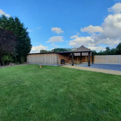a large yard with a building and a grass field at Tussenbeke in Lede