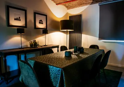 a dining room with a table and chairs and lights at Huis Bertem in Bertem