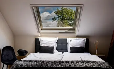 a bedroom with a large bed with a window at Huis Bertem in Bertem