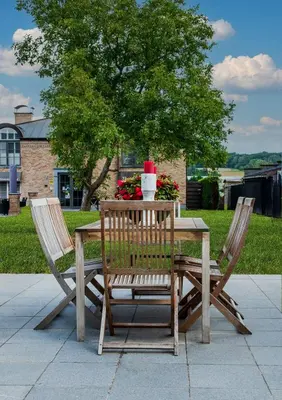 a wooden table with two chairs and a drink on it at Huis Bertem in Bertem