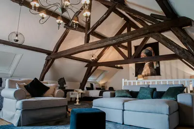 a living room with couches and a ceiling with beams at Huis Bertem in Bertem