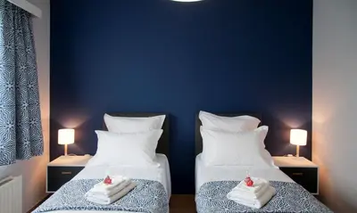 two beds in a room with blue walls at Wellintown Guest House in Waterloo