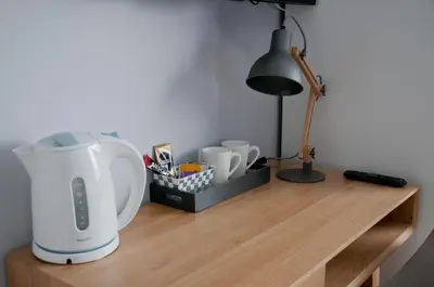 a coffee maker on a wooden table with a lamp at Wellintown Guest House in Waterloo