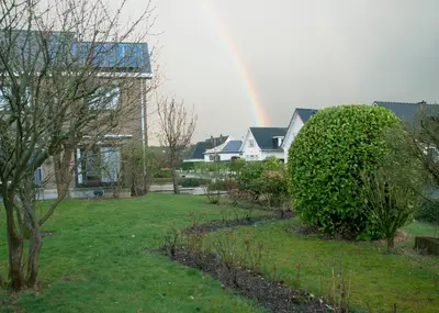 a rainbow in the sky over a yard with houses at Wellintown Guest House in Waterloo