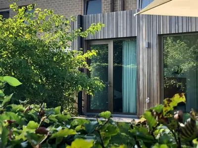 a house with sliding glass doors in a yard at Het Nekkerhof B&Bio in Mechelen