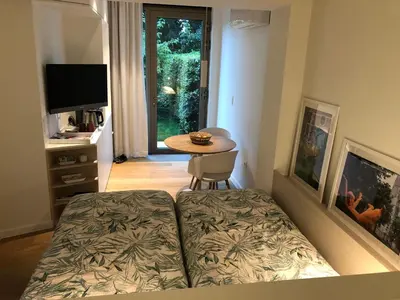 a bedroom with a bed and a table and a television at Het Nekkerhof B&Bio in Mechelen