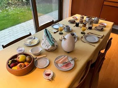 a table with food and a bowl of fruit on it at Het Nekkerhof B&Bio in Mechelen