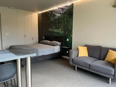 a room with a bed and a couch and a table at Bleekhoeve in Olen