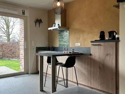 a kitchen with a table and two stools at Bleekhoeve in Olen