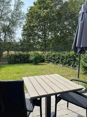 a picnic table and an umbrella on a patio at Bleekhoeve in Olen