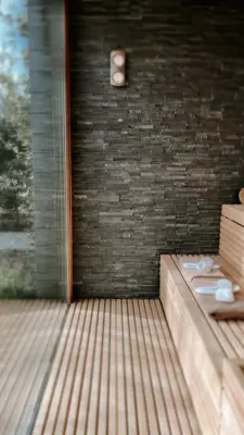 a bathroom with a toilet on a brick wall at Lit de Clémot in Merelbeke