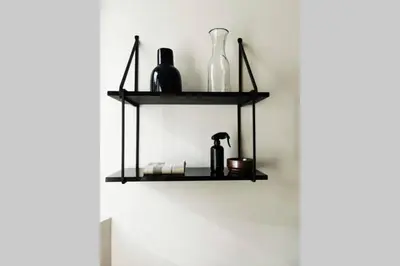 a black shelf on a wall with bottles and glasses at De Flat - Licht en luxueus appartement bij Het Zuid in Antwerp