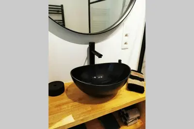 a black bowl on a wooden table with a mirror at De Flat - Licht en luxueus appartement bij Het Zuid in Antwerp