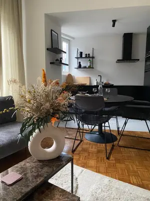 a living room with a vase of flowers on a table at De Flat - Licht en luxueus appartement bij Het Zuid in Antwerp