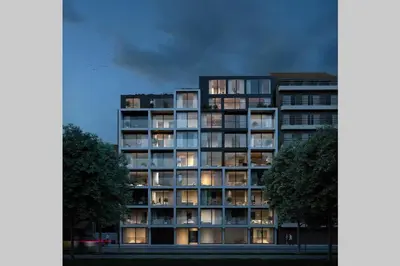 a tall apartment building with its lights on at Schitterend nieuwbouw appartement in Gent in Ghent