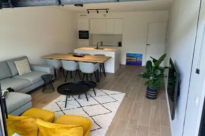 a kitchen and living room with a table and chairs at Schitterend nieuwbouw appartement in Gent in Ghent
