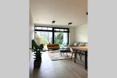 a living room with a table and chairs at Schitterend nieuwbouw appartement in Gent in Ghent