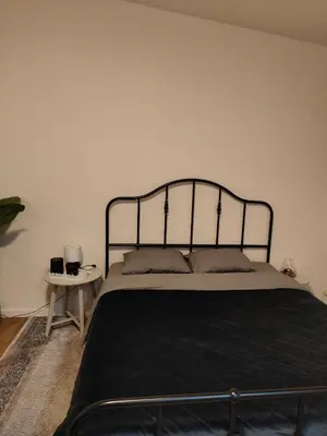 a bedroom with a bed with a black metal headboard at Mica beauty & wellness center in Temse