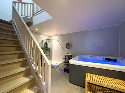 a large bathroom with a hot tub and stairs at Mica beauty & wellness center in Temse