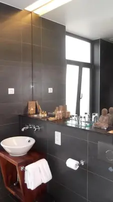 a bathroom with a white sink and a window at Art de Sejour - B&B in Brussels