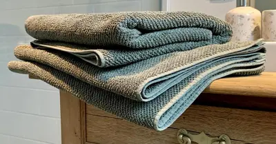 a pile of towels sitting on top of a wooden table at b&b Meilrijk in Diest