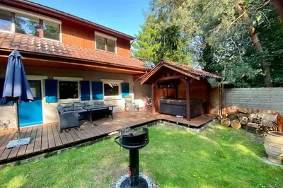 a backyard with a grill and a house at Charming house in the woods with private wellness in Schilde
