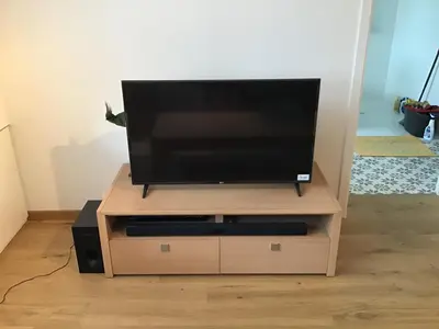 a flat screen tv on a wooden entertainment center at Charming house in the woods with private wellness in Schilde