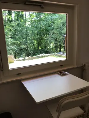a window in a room with a white desk at Charming house in the woods with private wellness in Schilde