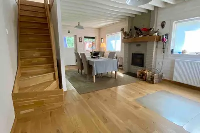 a living room with a table and a fireplace at Charming house in the woods with private wellness in Schilde