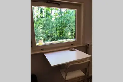 a small table in a room with a window at Charming house in the woods with private wellness in Schilde