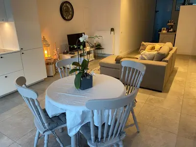 a living room with a table and chairs and a couch at Charming modern apartment in the heart of Antwerp with optional private parking in Antwerp