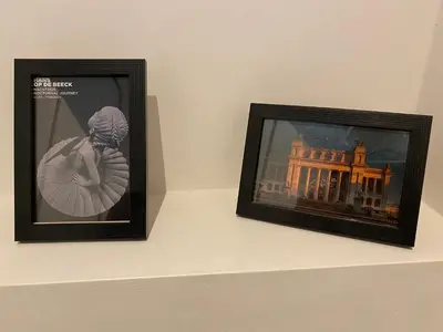 two framed photographs on a shelf with a picture of a building at Charming modern apartment in the heart of Antwerp with optional private parking in Antwerp