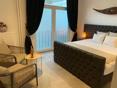 a bedroom with a large bed and a balcony at Charming modern apartment in the heart of Antwerp with optional private parking in Antwerp