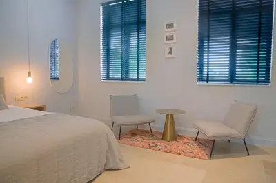a bedroom with two chairs and a bed and a table at Cire Bed and Breakfast in Meerhout