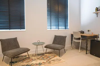 a room with two chairs and a table and two windows at Cire Bed and Breakfast in Meerhout
