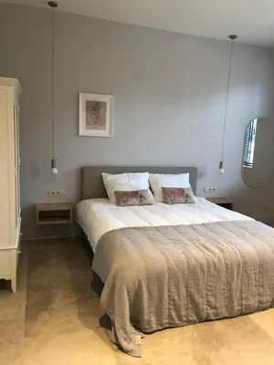 a bedroom with a large bed with white sheets at Cire Bed and Breakfast in Meerhout