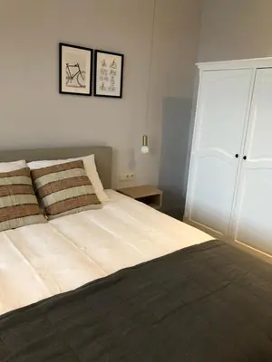a bedroom with a large bed and a white cabinet at Cire Bed and Breakfast in Meerhout