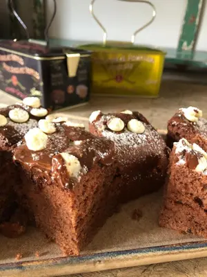 a piece of cake with chocolate and bananas on a plate at Cire Bed and Breakfast in Meerhout