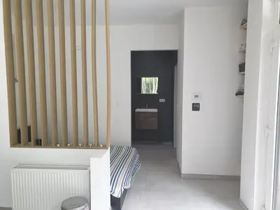 a hallway with a stairwell with a door and a bench at Eden in Sint-Pauwels
