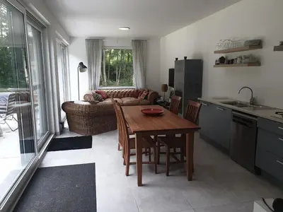a kitchen and living room with a table and a couch at Eden in Sint-Pauwels