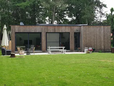 a small building with a picnic table in a yard at Eden in Sint-Pauwels