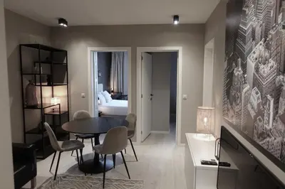 a room with a table and chairs and a bedroom at 3 Room Luxury Design Apartment with Airconditioning, Close to Gent St-Pieters Station in Ghent