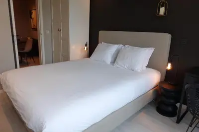 a bed with white sheets and pillows in a room at 3 Room Luxury Design Apartment with Airconditioning, Close to Gent St-Pieters Station in Ghent