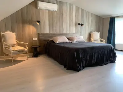 a bedroom with a bed with two chairs and a window at B&B Silentium in Tielt